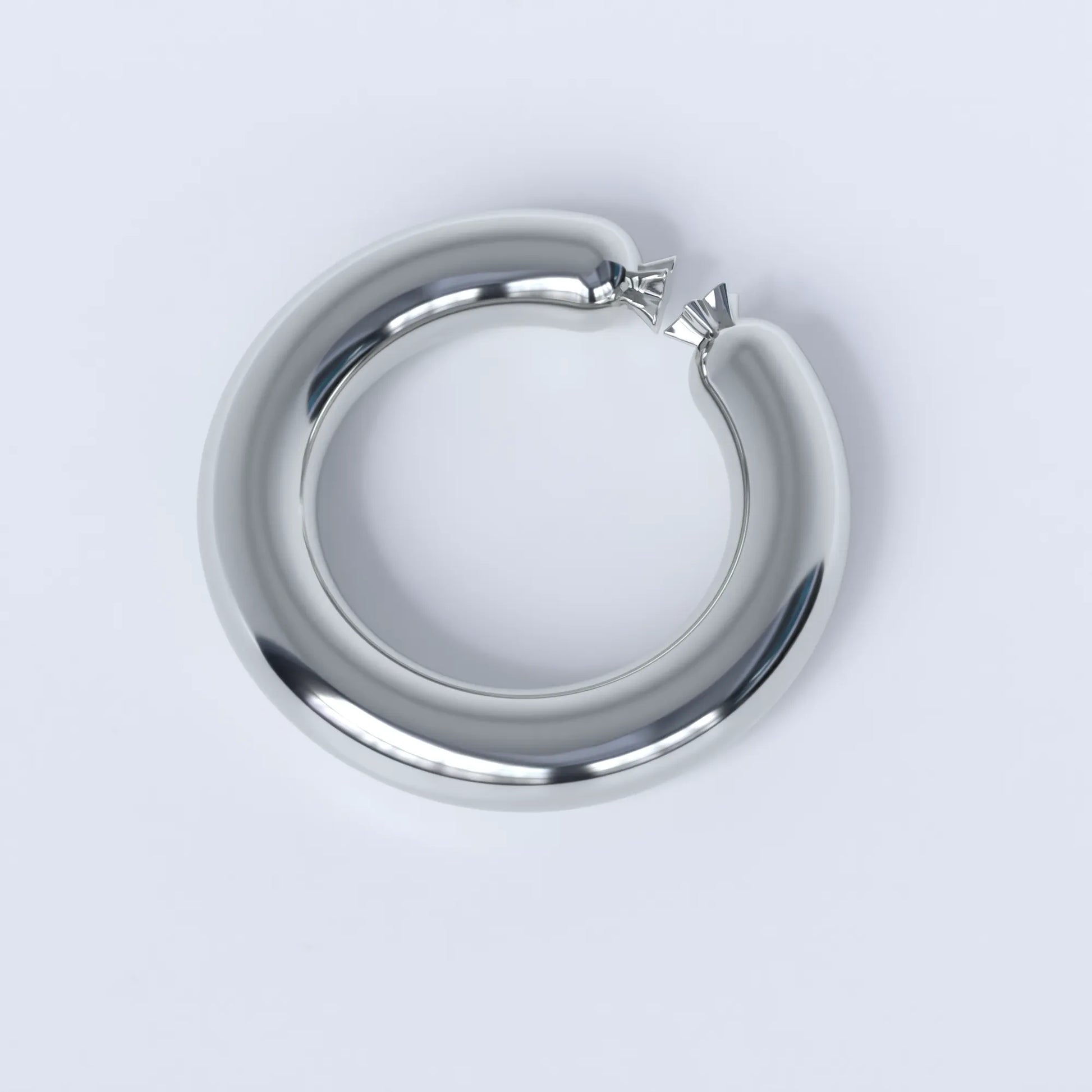 Sterling silver ring shaped like a sausage bent into a circle on a light grey background