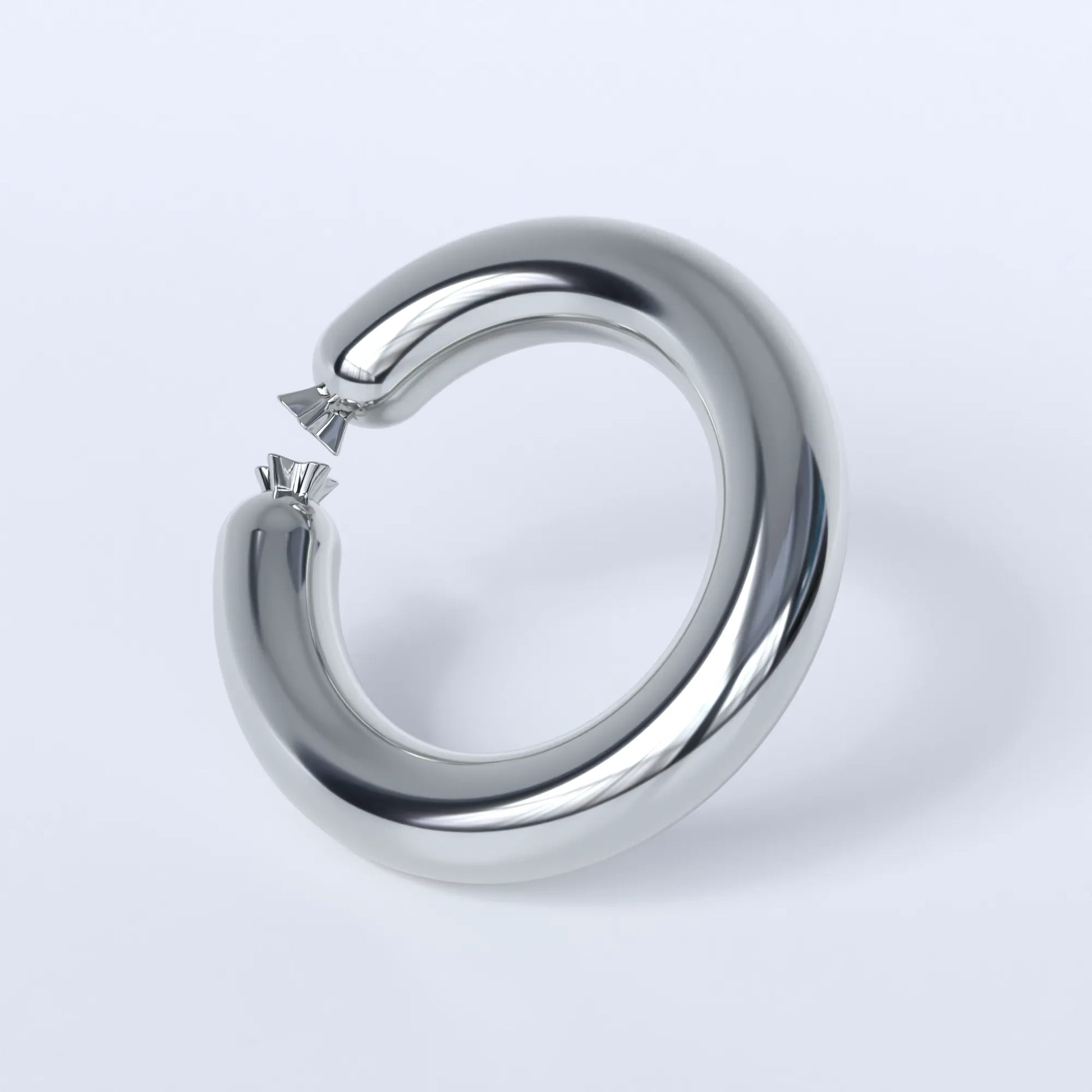 Sterling silver ring shaped like a sausage bent into a circle on a light grey background