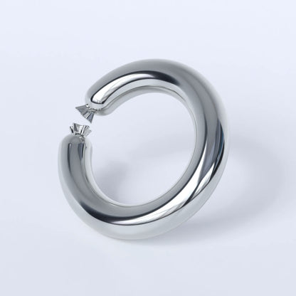 Sterling silver ring shaped like a sausage bent into a circle on a light grey background