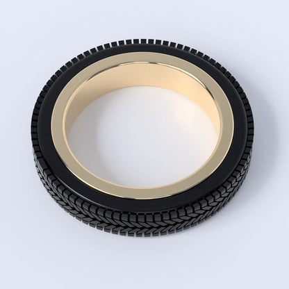 Gold ring on a white background, this ring is shaped like a car's tyre, and shows the design in 14ct gold with the 3d printed tyre